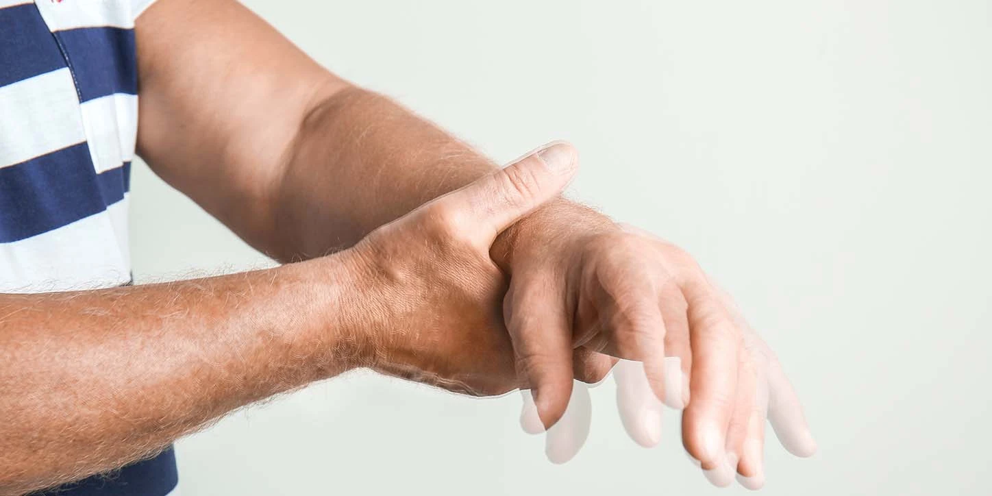 homem com as mãos tremendo, sendo esses um dos sinais de parkinson