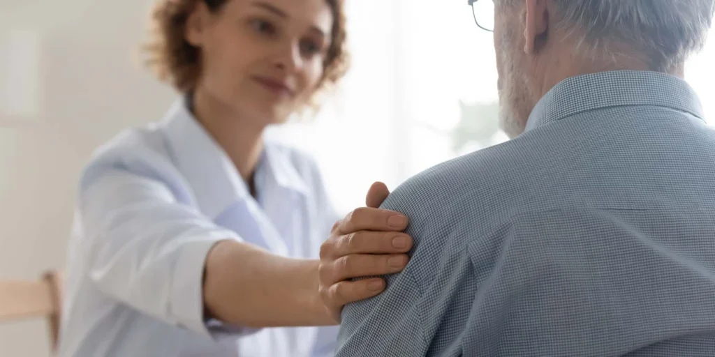 Homem de meia idade discutindo sobre parkinson e saúde mental com a psicóloga
