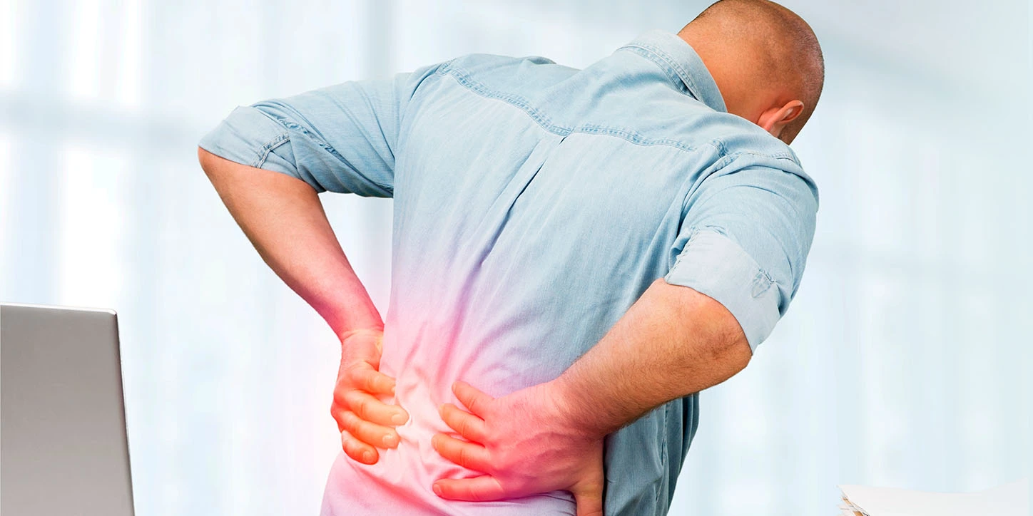 Homem interrompendo o seu trabalho por estar sentindo dor nas costas
