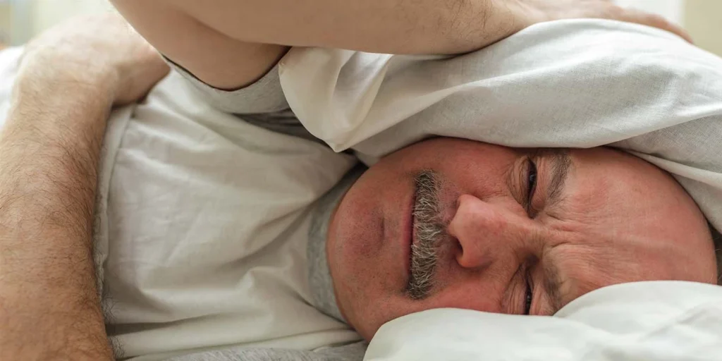 Idoso deitado sem conseguir dormir porque o distúrbio do sono é um dos sintomas não mortores do parkinson