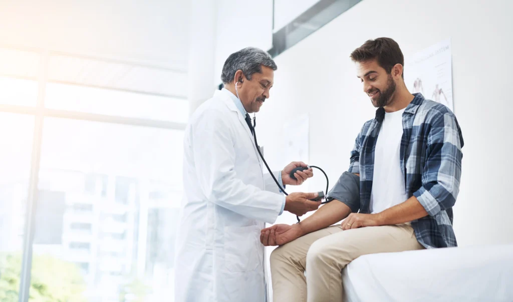 Médico realiza exame clínico em paciente jovem, auxiliando na identificação de sinais motores de Parkinsonismo Juvenil.